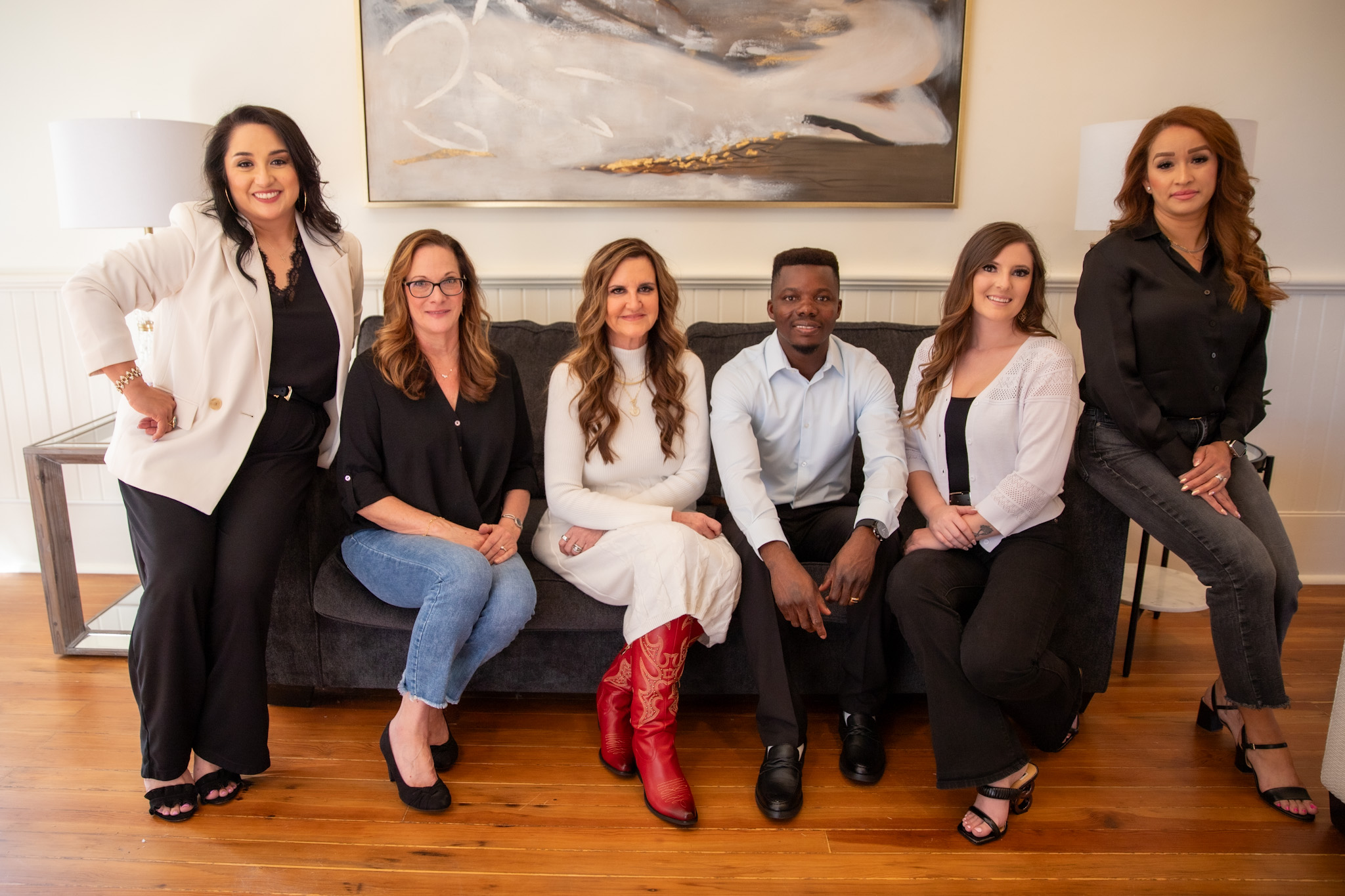 Group of six mortgage professionals from American Liberty Mortgage in Victoria, Texas, posing together in a modern office setting, showcasing their commitment to personalized service in the mortgage process.